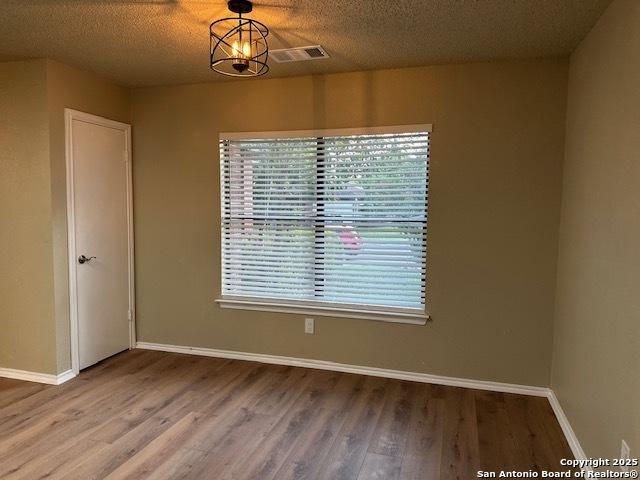 16454 Blanco Ky, San Antonio, TX 78247 - unfurnished room featuring wood finished floors and a textured ceiling