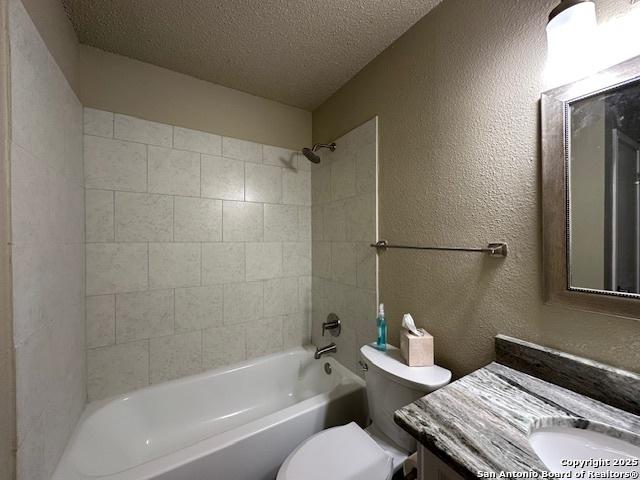 16454 Blanco Ky, San Antonio, TX 78247 - bathroom with a textured ceiling, vanity, shower / washtub combination, and a textured wall