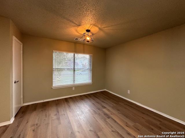 16454 Blanco Ky, San Antonio, TX 78247 - spare room featuring dark wood-style floors and a textured ceiling