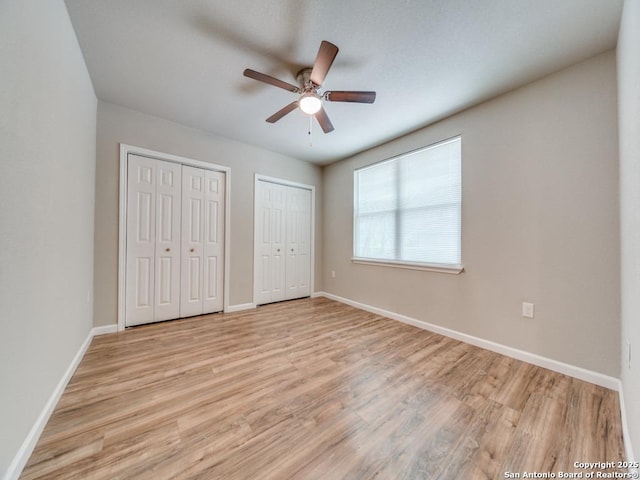 122 Adrian, San Antonio, TX 78213 - unfurnished bedroom with multiple closets, light wood-style floors, and a ceiling fan