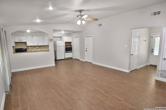 7730 Pipers Vw, San Antonio, TX 78251 - unfurnished living room with ceiling fan, arched walkways, dark wood-type flooring, and lofted ceiling