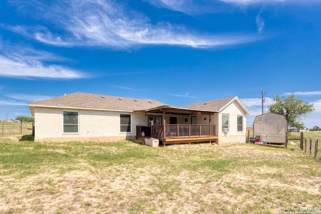 177 Lakeview Cir, La Vernia, TX 78121 - rear view of property featuring a deck, brick siding, a storage unit, and roof with shingles