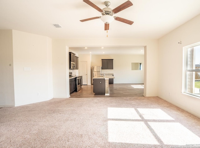 7335 Sharma Vly, San Antonio, TX 78252 - unfurnished living room featuring light carpet and a ceiling fan