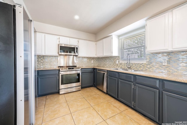 6914 Ludgate, San Antonio, TX 78239 - kitchen featuring stainless steel appliances, gray cabinetry, white cabinetry, backsplash, and light tile patterned floors