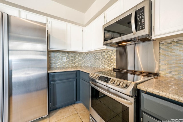 6914 Ludgate, San Antonio, TX 78239 - kitchen with stainless steel appliances, decorative backsplash, white cabinets, light tile patterned floors, and light stone countertops