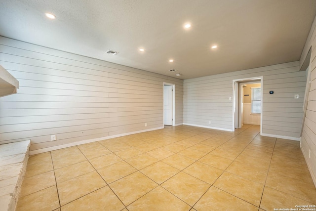 6914 Ludgate, San Antonio, TX 78239 - empty room with wood walls, recessed lighting, and light tile patterned flooring