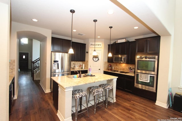 2514 Ladera Bnd, San Antonio, TX 78261 - kitchen featuring stainless steel appliances, arched walkways, backsplash, dark wood-style floors, and recessed lighting