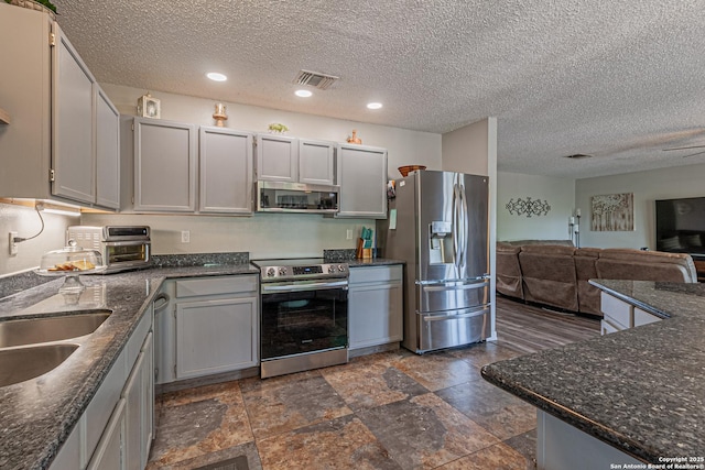 7907 Donshire, Converse, TX 78109 - kitchen with appliances with stainless steel finishes, open floor plan, a textured ceiling, dark stone countertops, and recessed lighting