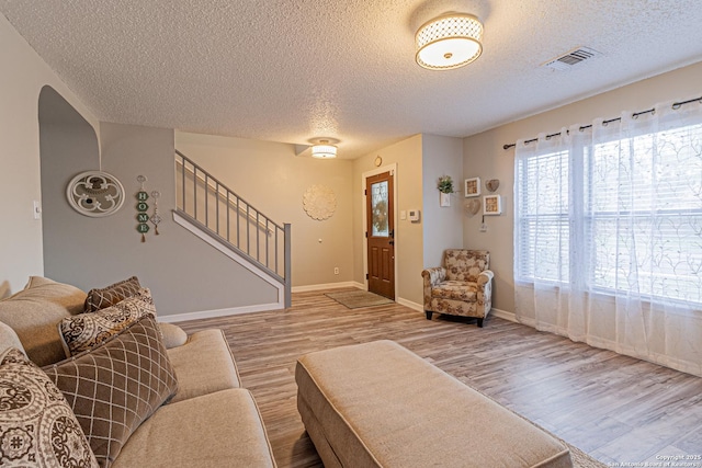 7907 Donshire, Converse, TX 78109 - living area featuring wood finished floors, stairway, and a textured ceiling