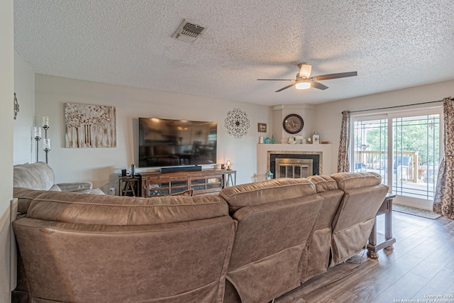 7907 Donshire, Converse, TX 78109 - living area with a ceiling fan, wood finished floors, a textured ceiling, and a fireplace