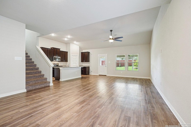 11518 Biddle, San Antonio, TX 78253 - unfurnished living room featuring lofted ceiling, light wood-style flooring, a ceiling fan, and stairs