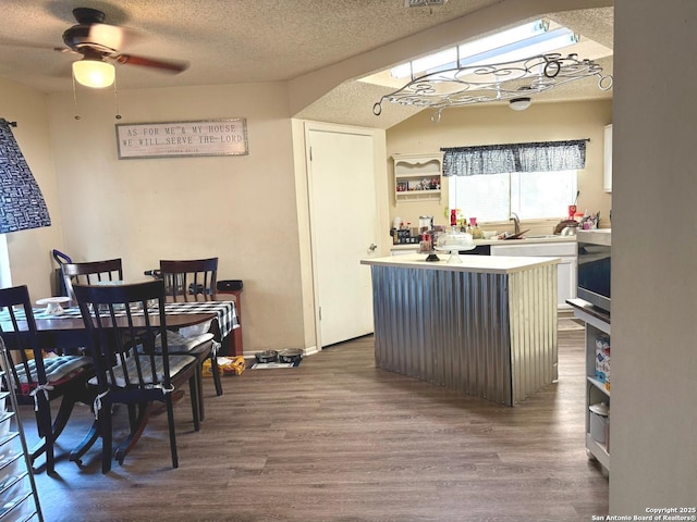 11733 Spring Rdg, San Antonio, TX 78249 - kitchen with dark wood finished floors, a center island, a ceiling fan, light countertops, and a textured ceiling