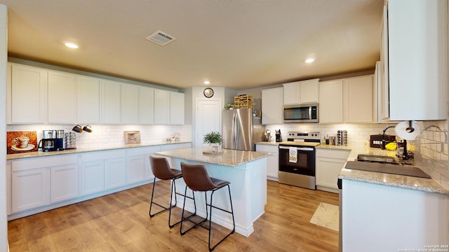 408 River Sta, Cibolo, TX 78108 - kitchen featuring appliances with stainless steel finishes, tasteful backsplash, a center island, a breakfast bar area, and recessed lighting