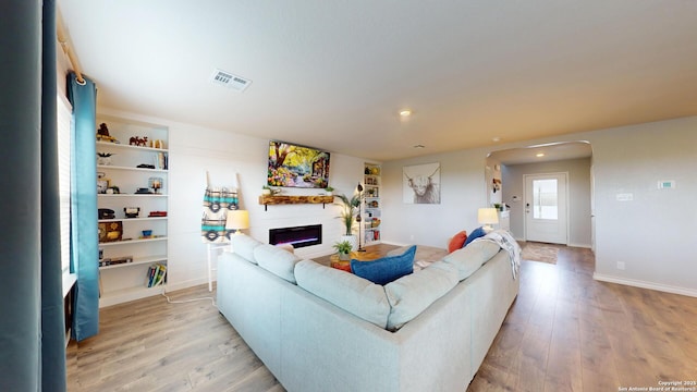 408 River Sta, Cibolo, TX 78108 - living room featuring a fireplace, light wood-style flooring, arched walkways, and recessed lighting