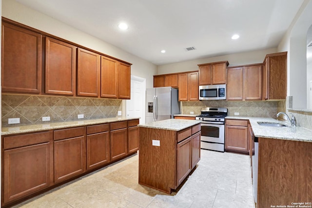 11708 Northern Star, Schertz, TX 78154 - kitchen featuring appliances with stainless steel finishes, light stone countertops, brown cabinets, decorative backsplash, and recessed lighting