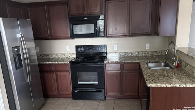 6322 Channel Vw, San Antonio, TX 78222 - kitchen with black appliances, light stone counters, and light tile patterned floors