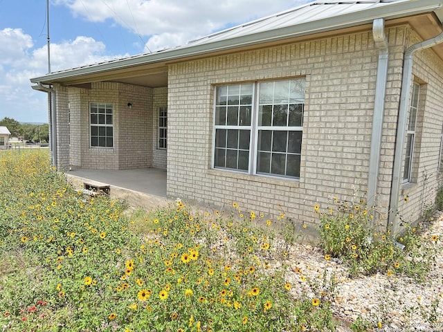 168 Great Oaks Blvd, La Vernia, TX 78121 - view of side of home featuring brick siding and a patio