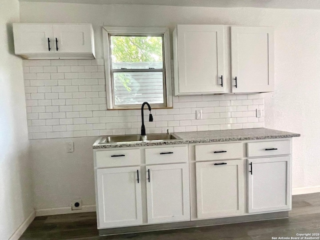 3022 El Paso, San Antonio, TX 78207 - kitchen featuring backsplash, light stone counters, white cabinets, and dark wood finished floors