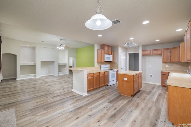 173 Great Oaks Ln, Vernia, TX 78121 - kitchen with white appliances, light countertops, open floor plan, light wood-type flooring, and ceiling fan