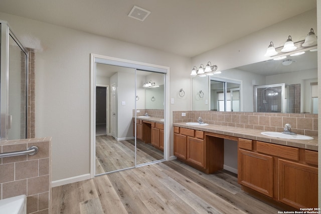173 Great Oaks Ln, Vernia, TX 78121 - full bath with double vanity, decorative backsplash, wood finished floors, a tile shower, and a tub