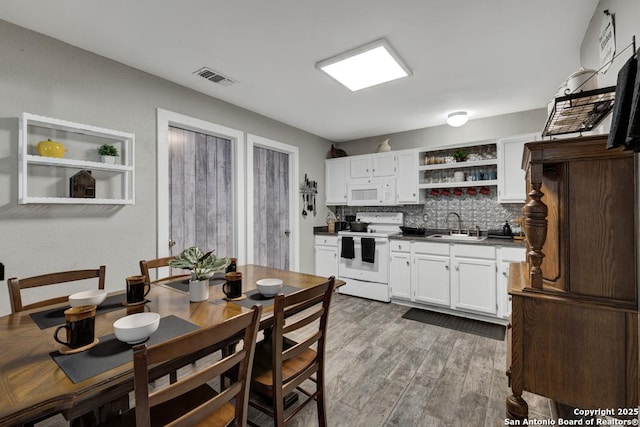 332 W Klein, Seguin, TX 78155 - kitchen featuring white appliances, open shelves, dark countertops, white cabinets, and tasteful backsplash