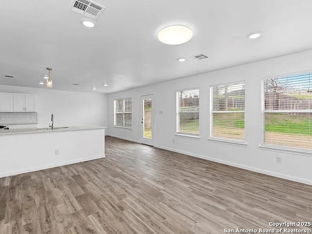 221 Peppergrass Cv, Kyle, TX 78640 - unfurnished living room featuring plenty of natural light, wood finished floors, and recessed lighting