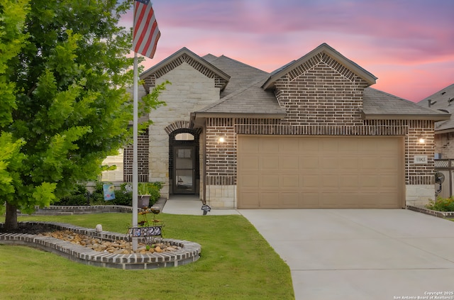13822 Greater Straw, San Antonio, TX 78254 - french country inspired facade featuring stone siding, a garage, driveway, brick siding, and a yard