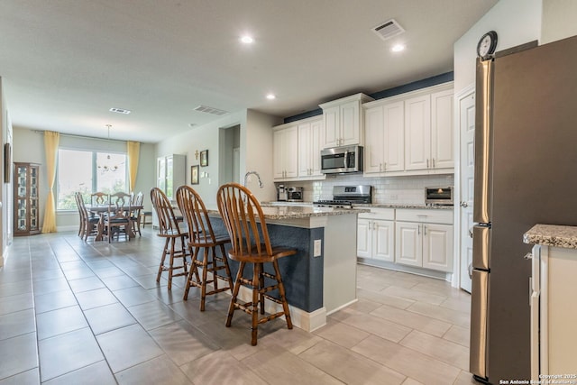 13822 Greater Straw, San Antonio, TX 78254 - kitchen featuring appliances with stainless steel finishes, decorative backsplash, a kitchen breakfast bar, recessed lighting, and white cabinetry