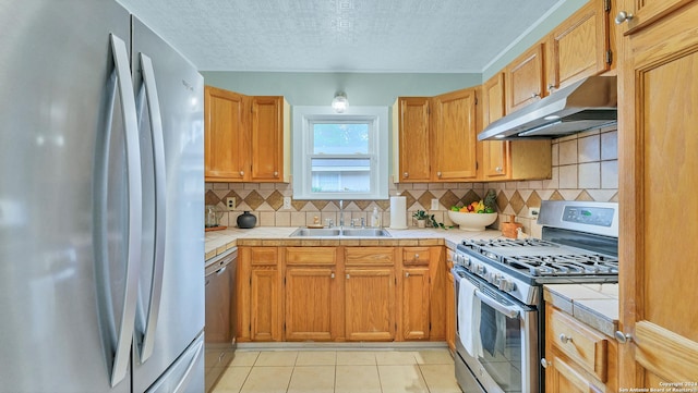 1261 Mill, New Braunfels, TX 78130 - kitchen with stainless steel appliances, under cabinet range hood, tile counters, decorative backsplash, and a textured ceiling