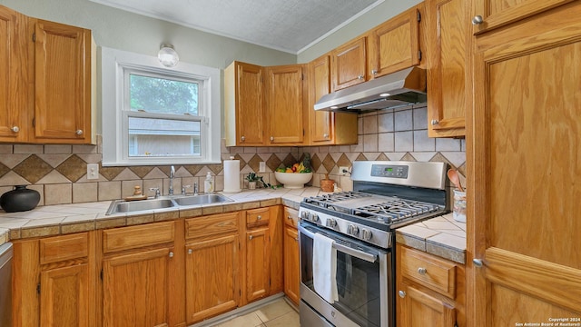 1261 Mill, New Braunfels, TX 78130 - kitchen with gas range, under cabinet range hood, crown molding, and tile counters