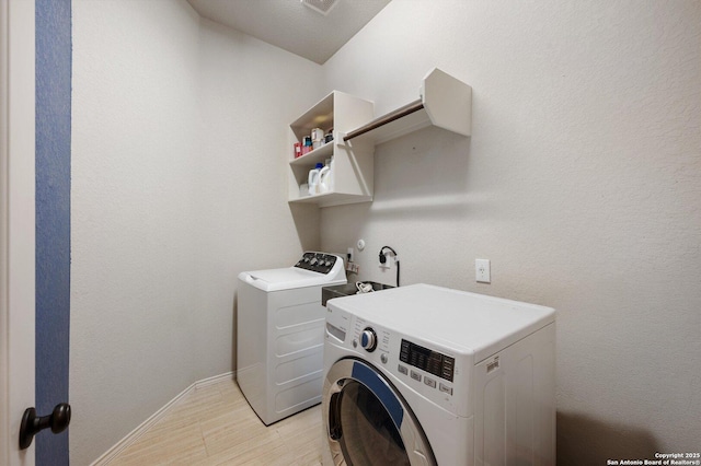 2129 Rustling Way, Seguin, TX 78155 - laundry room featuring washer and dryer and light wood finished floors