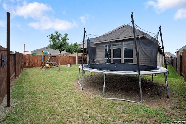 2129 Rustling Way, Seguin, TX 78155 - rear view of property with a trampoline, a playground, and a fenced backyard