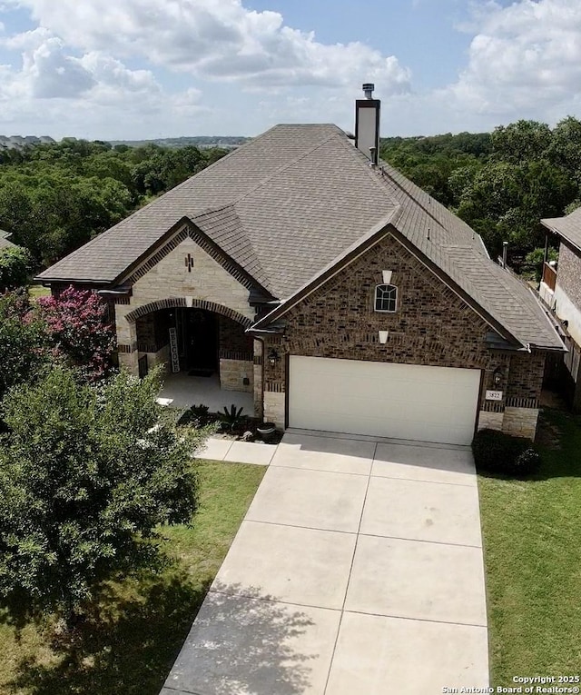3822 Cordoba Crk, San Antonio, TX 78259 - french provincial home with roof with shingles, stone siding, a chimney, and driveway