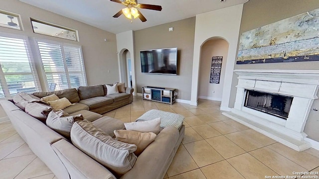 3822 Cordoba Crk, San Antonio, TX 78259 - living room with arched walkways, light tile patterned flooring, a ceiling fan, a fireplace, and vaulted ceiling