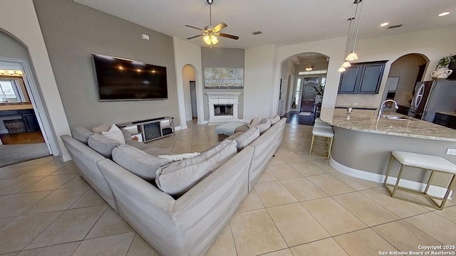 3822 Cordoba Crk, San Antonio, TX 78259 - living area with arched walkways, light tile patterned flooring, ceiling fan, a fireplace, and recessed lighting