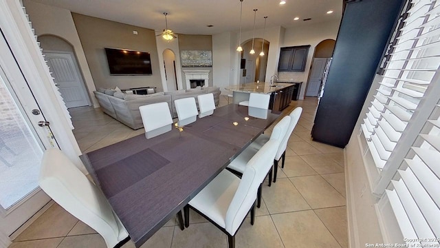 3822 Cordoba Crk, San Antonio, TX 78259 - dining space featuring arched walkways, light tile patterned floors, ceiling fan, a fireplace, and recessed lighting