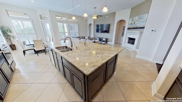 3822 Cordoba Crk, San Antonio, TX 78259 - kitchen featuring a fireplace, open floor plan, arched walkways, decorative light fixtures, and ceiling fan