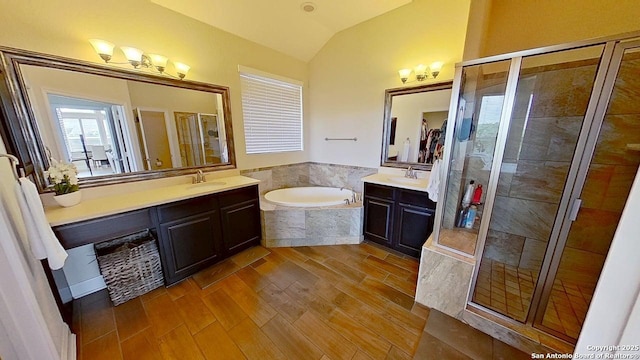 3822 Cordoba Crk, San Antonio, TX 78259 - bathroom with a shower stall, vaulted ceiling, two vanities, a garden tub, and wood finished floors