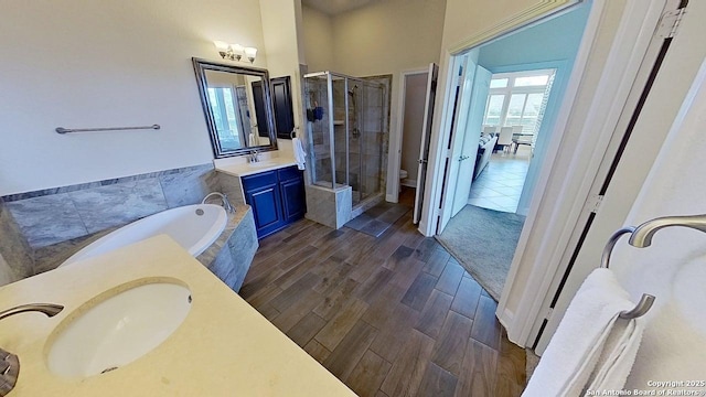 3822 Cordoba Crk, San Antonio, TX 78259 - bathroom with vanity, a stall shower, a garden tub, and wood finished floors