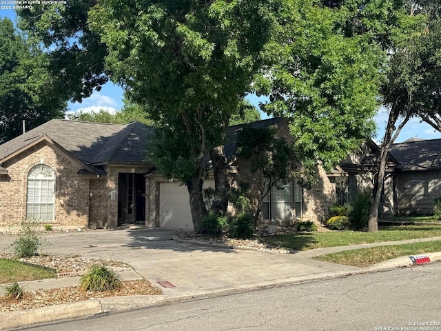 13711 Auburn Oaks, San Antonio, TX 78247 - view of front of house with brick siding, a garage, driveway, and a shingled roof