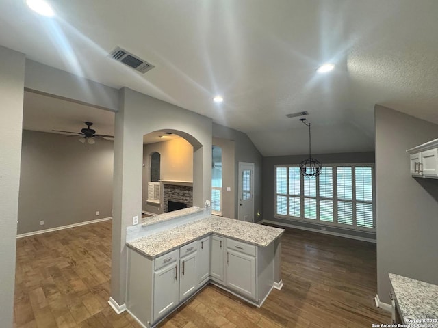 13711 Auburn Oaks, San Antonio, TX 78247 - kitchen with arched walkways, dark wood-style flooring, a fireplace, vaulted ceiling, and a ceiling fan