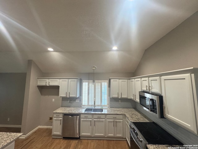 13711 Auburn Oaks, San Antonio, TX 78247 - kitchen with appliances with stainless steel finishes, wood finished floors, white cabinets, vaulted ceiling, and light stone counters