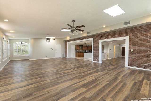 18510 Paloma Wood, San Antonio, TX 78259 - unfurnished living room featuring ceiling fan, dark wood finished floors, and brick wall