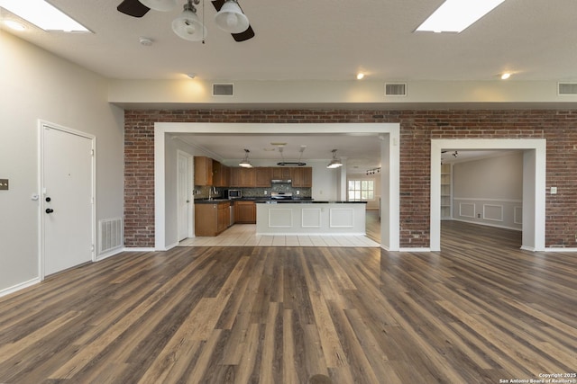 18510 Paloma Wood, San Antonio, TX 78259 - unfurnished living room featuring wood finished floors, a ceiling fan, and brick wall