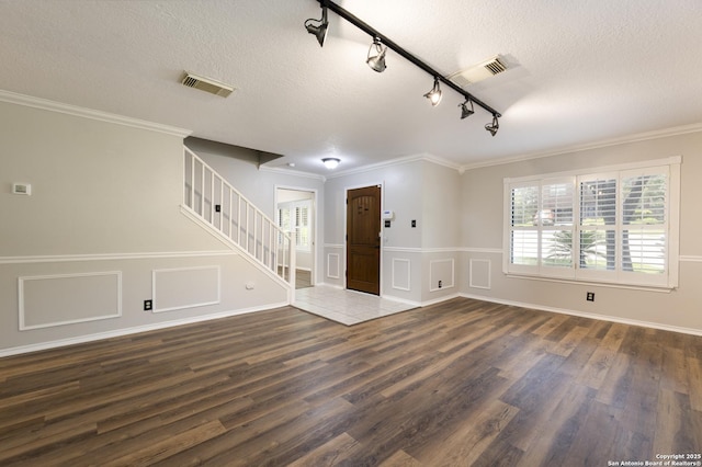 18510 Paloma Wood, San Antonio, TX 78259 - foyer entrance featuring dark wood-style floors, a textured ceiling, stairs, rail lighting, and a wainscoted wall