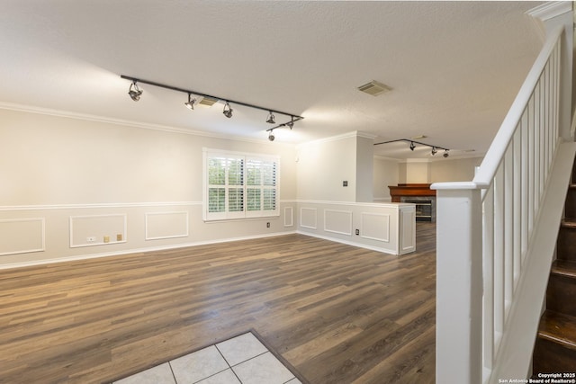 18510 Paloma Wood, San Antonio, TX 78259 - empty room featuring track lighting, crown molding, stairs, dark wood finished floors, and wainscoting