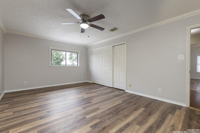 18510 Paloma Wood, San Antonio, TX 78259 - unfurnished bedroom with dark wood-style floors, crown molding, a textured ceiling, a closet, and a ceiling fan