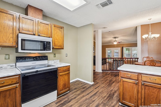 11063 Moonlit, San Antonio, TX 78249 - kitchen featuring electric stove, stainless steel microwave, dark wood-style flooring, a chandelier, and light countertops