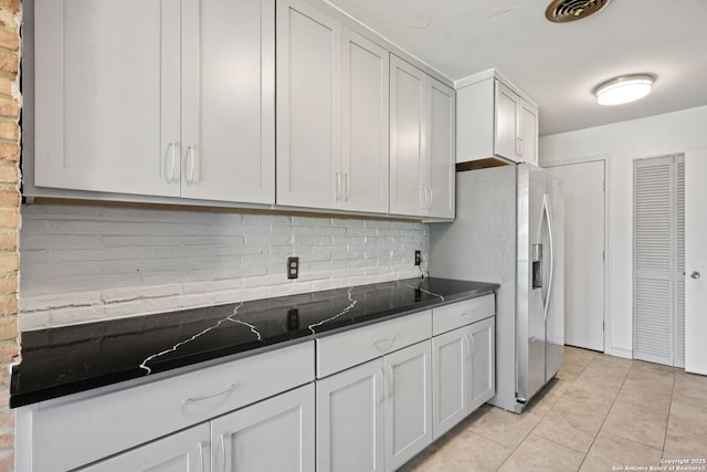 250 Maplewood, San Antonio, TX 78216 - kitchen featuring stainless steel fridge with ice dispenser, dark countertops, light tile patterned floors, tasteful backsplash, and white cabinetry