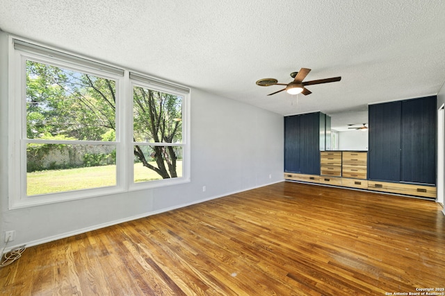 250 Maplewood, San Antonio, TX 78216 - empty room featuring a ceiling fan, wood finished floors, a textured ceiling, and healthy amount of natural light